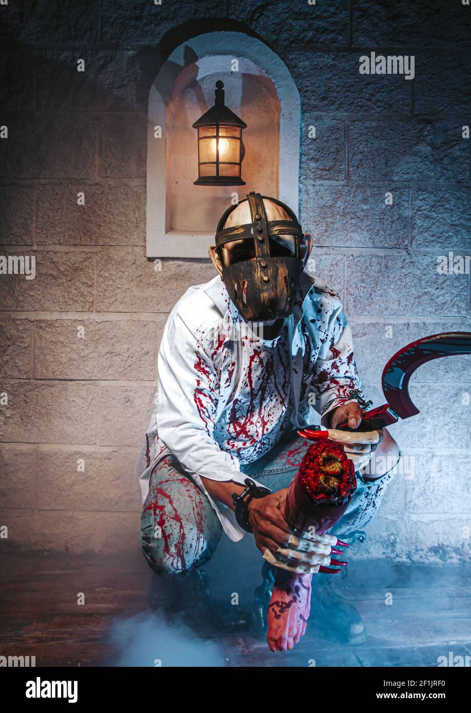 Creepy, costume di halloween, uomo incatenato con sangue e coltello, morte dell'uomo di Zombie il fantasma orrore drenare la pelle di sangue della mano è screamin Foto Stock