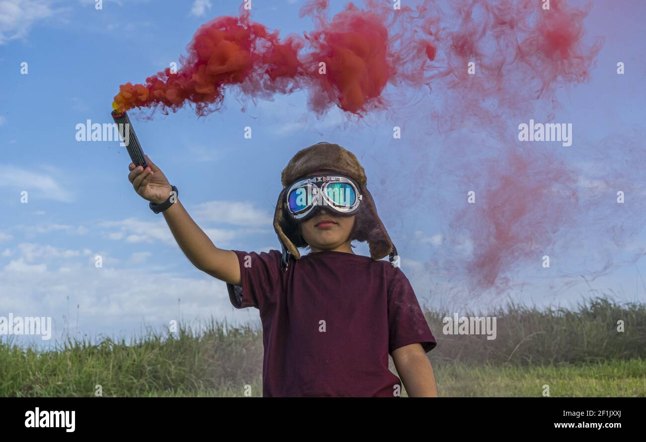 Little boy gioca con fumo colorato, indossando un cappello aviatore degli  anni '20 e occhiali da pilota in aeroplano Foto stock - Alamy