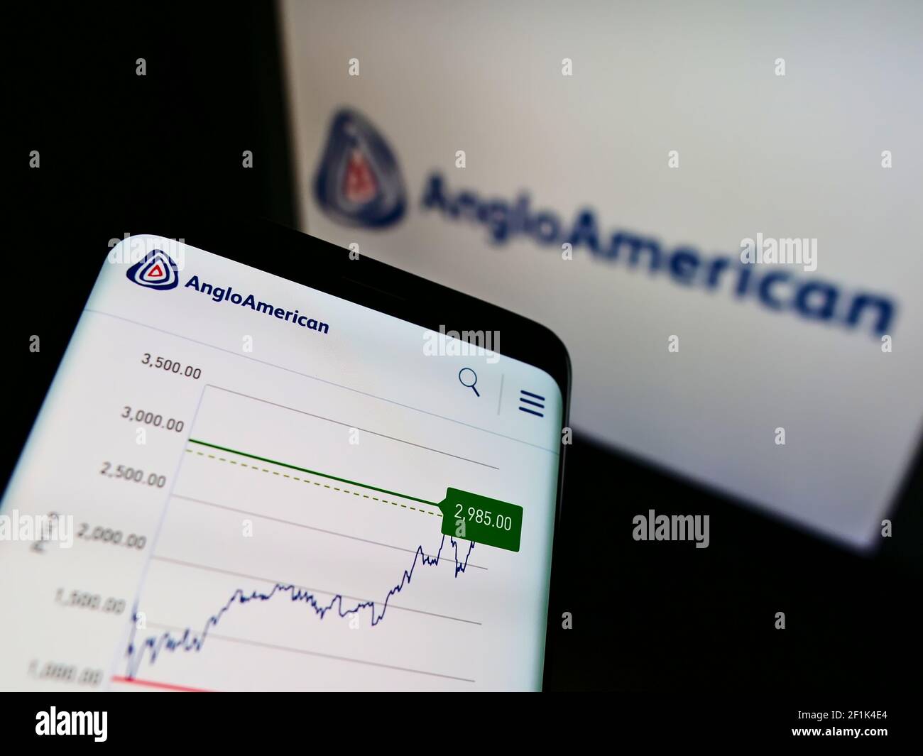 Telefono cellulare con logo di metalli globali e società mineraria Anglo American plc sullo schermo di fronte alla pagina web. Mettere a fuoco la parte superiore centrale del display del telefono. Foto Stock