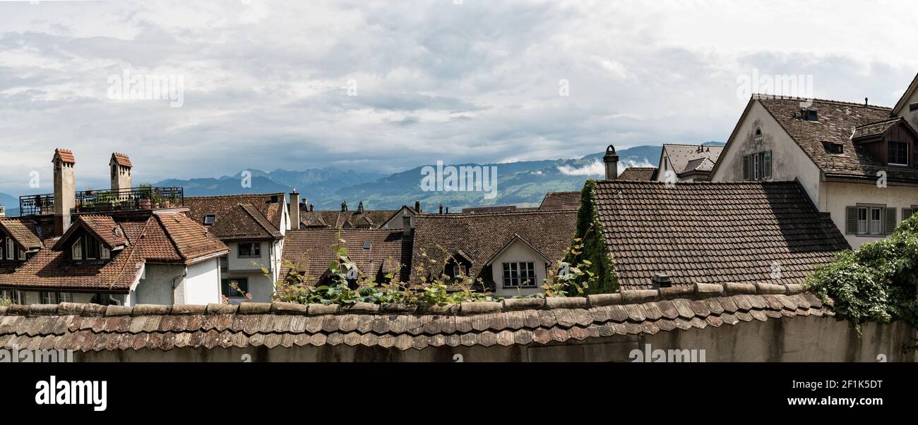 Vista panoramica di vecchie case e tetti in Europa con paesaggio di montagna dietro Foto Stock