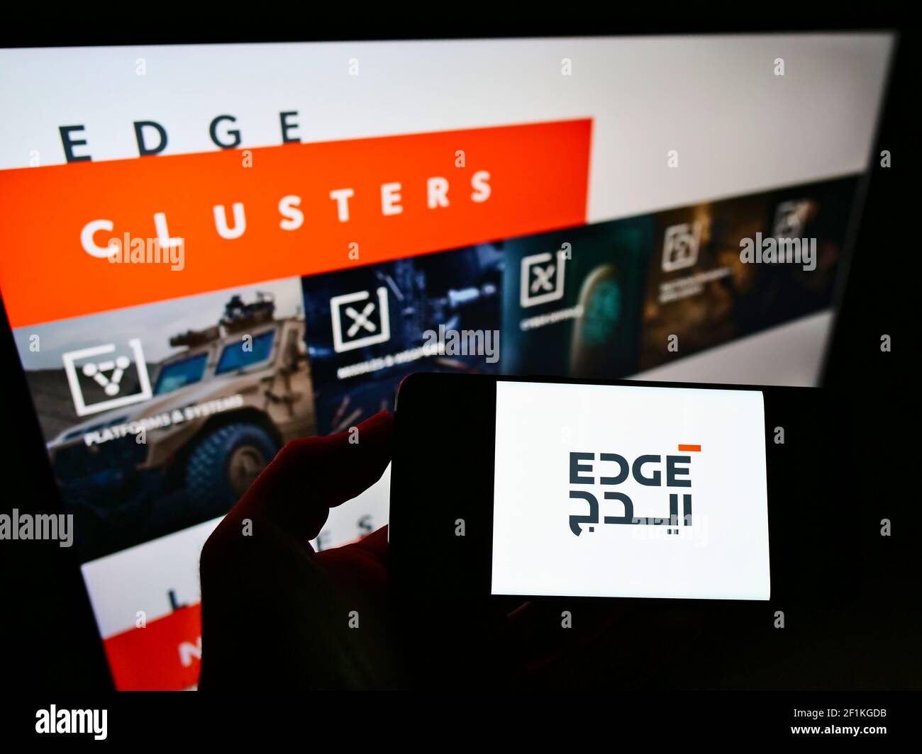Persona che detiene smartphone con il logo della società di difesa degli Emirati Arabi Uniti EDGE Group PJSC sullo schermo davanti al sito Web. Mettere a fuoco il display del telefono. Foto non modificata. Foto Stock