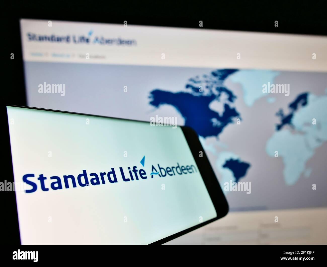 Smartphone con logo della società di investimento britannica Standard Life Aberdeen plc sullo schermo davanti alla pagina web. Mettere a fuoco al centro-sinistra del display del telefono. Foto Stock