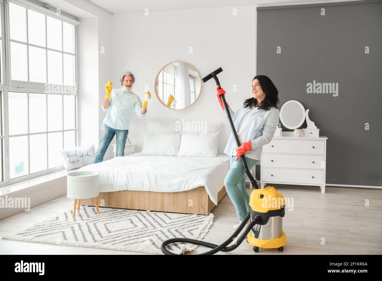 Coppie mature che puliscono la loro camera da letto Foto stock - Alamy