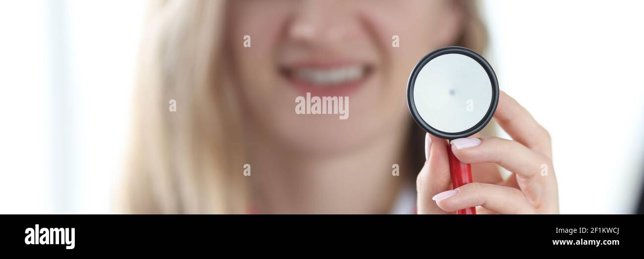 Donna medico terapeuta tenendo stetoscopio nelle sue mani closeup Foto Stock