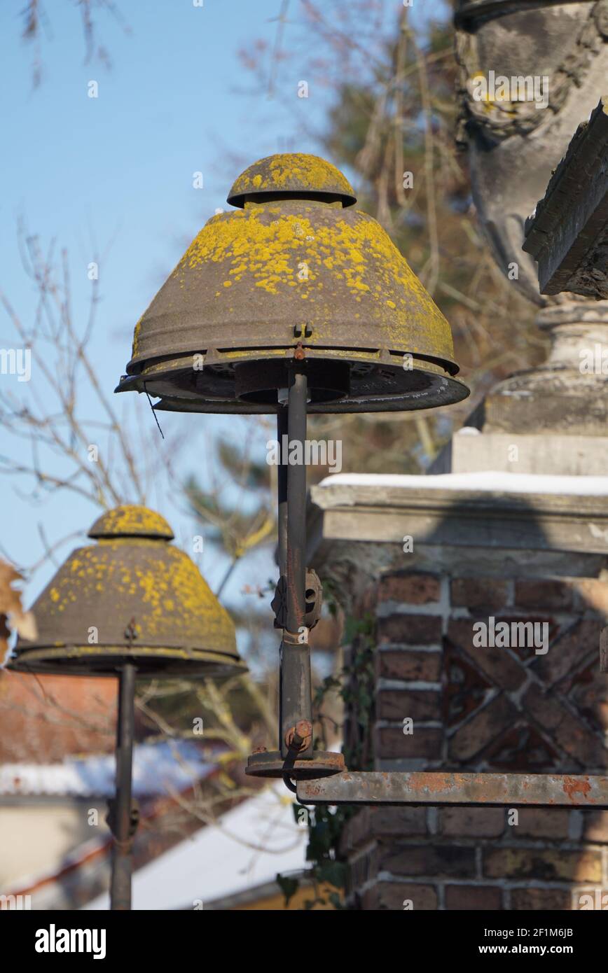 Vecchia lanterna di metallo arrugginita con muschio su a. muro di mattoni Foto Stock
