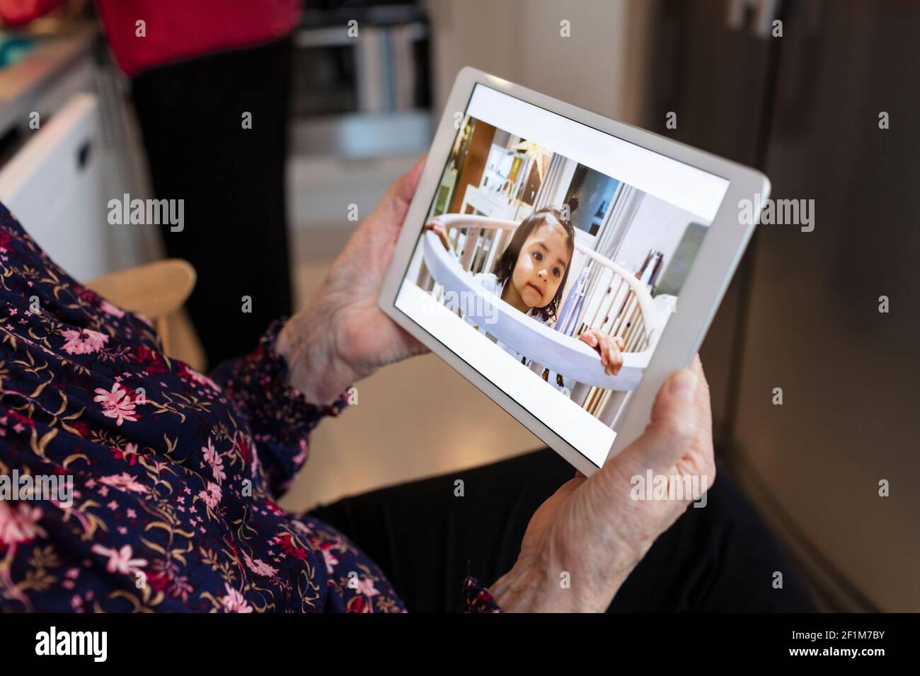 Mani che tengono il tablet digitale con l'immagine della bambina Foto Stock