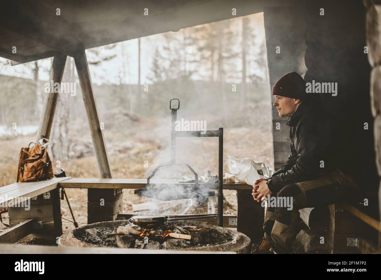 Uomo che si rilassa vicino al fuoco Foto Stock