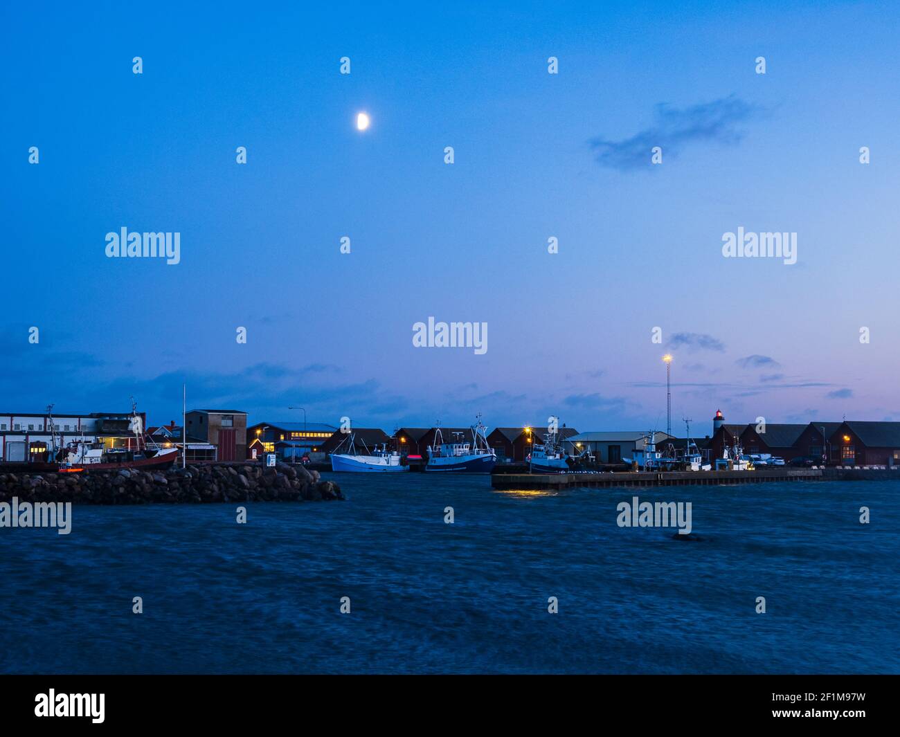 Luna nel cielo di sera sopra il porto Foto Stock