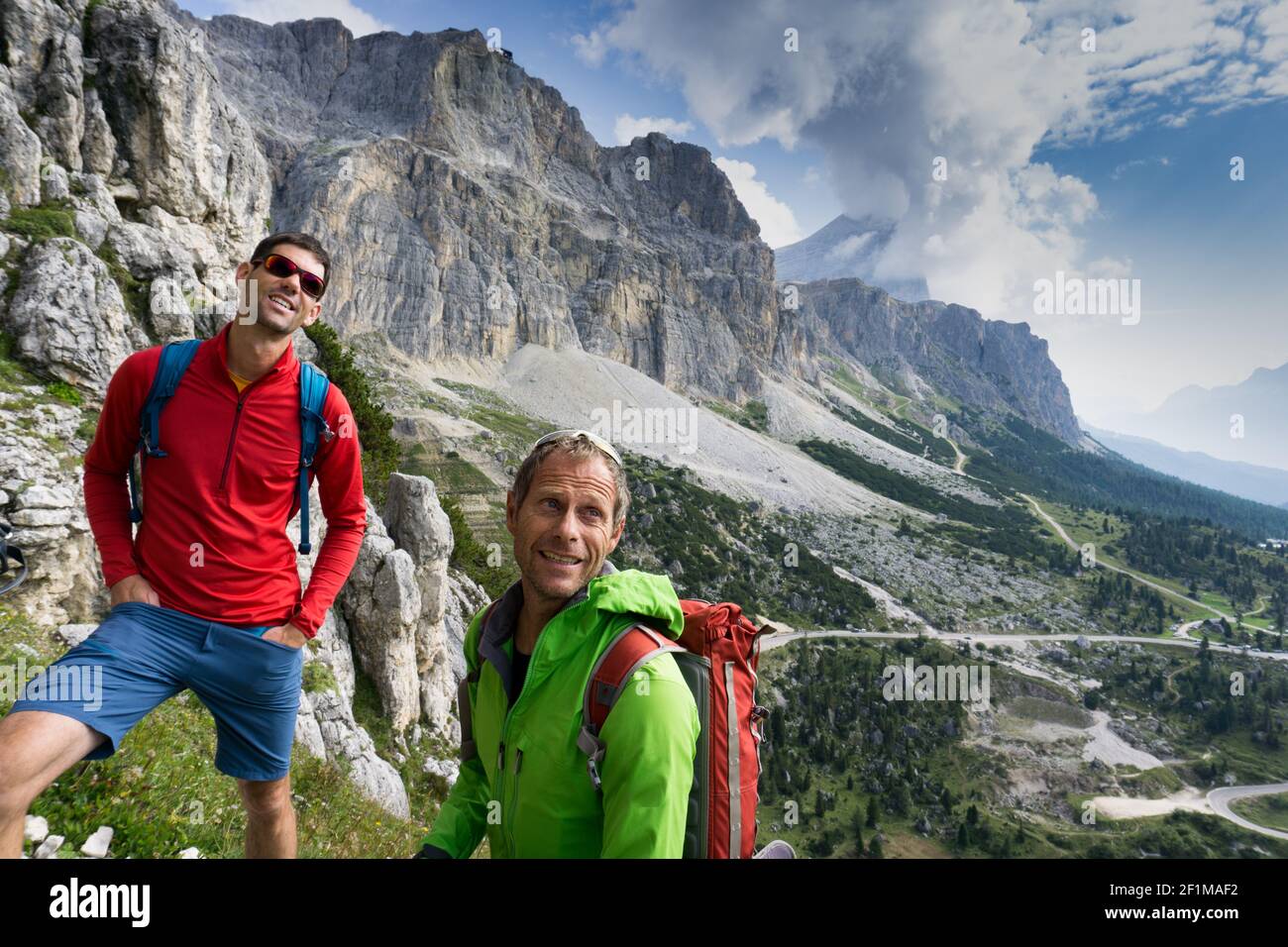 Guida di montagna e cliente che cerca e controlla il percorso di arrampicata prima di loro Foto Stock