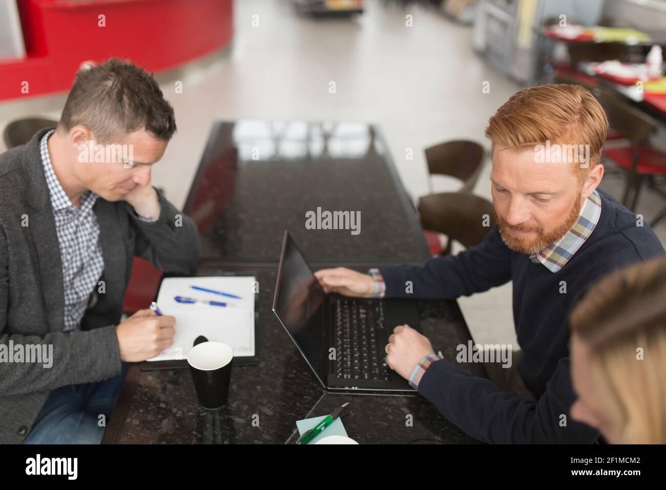 Colleghi che si riuniscono al caffè dell'aeroporto Foto Stock