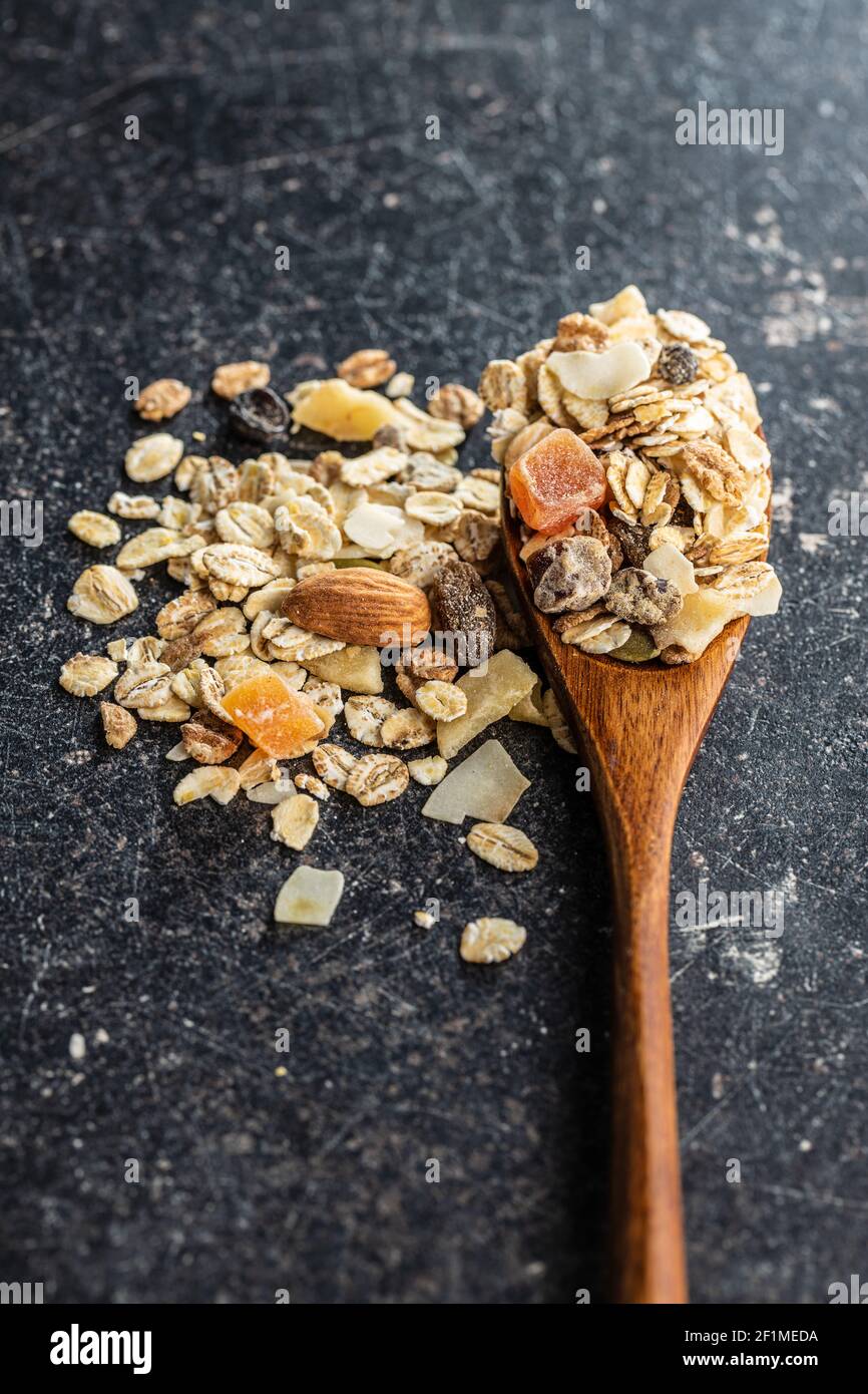 Colazione con cereali in cucchiaio di legno. Muesli sani con fiocchi  d'avena, noci e uvetta Foto stock - Alamy