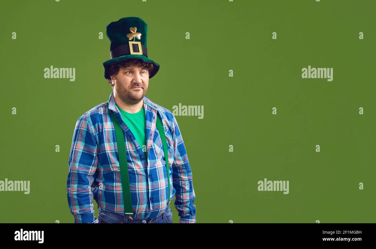 L'uomo con le decorazioni a pentola in cappelli Leprechaun è isolato su una copia verde sfondo dello spazio Foto Stock