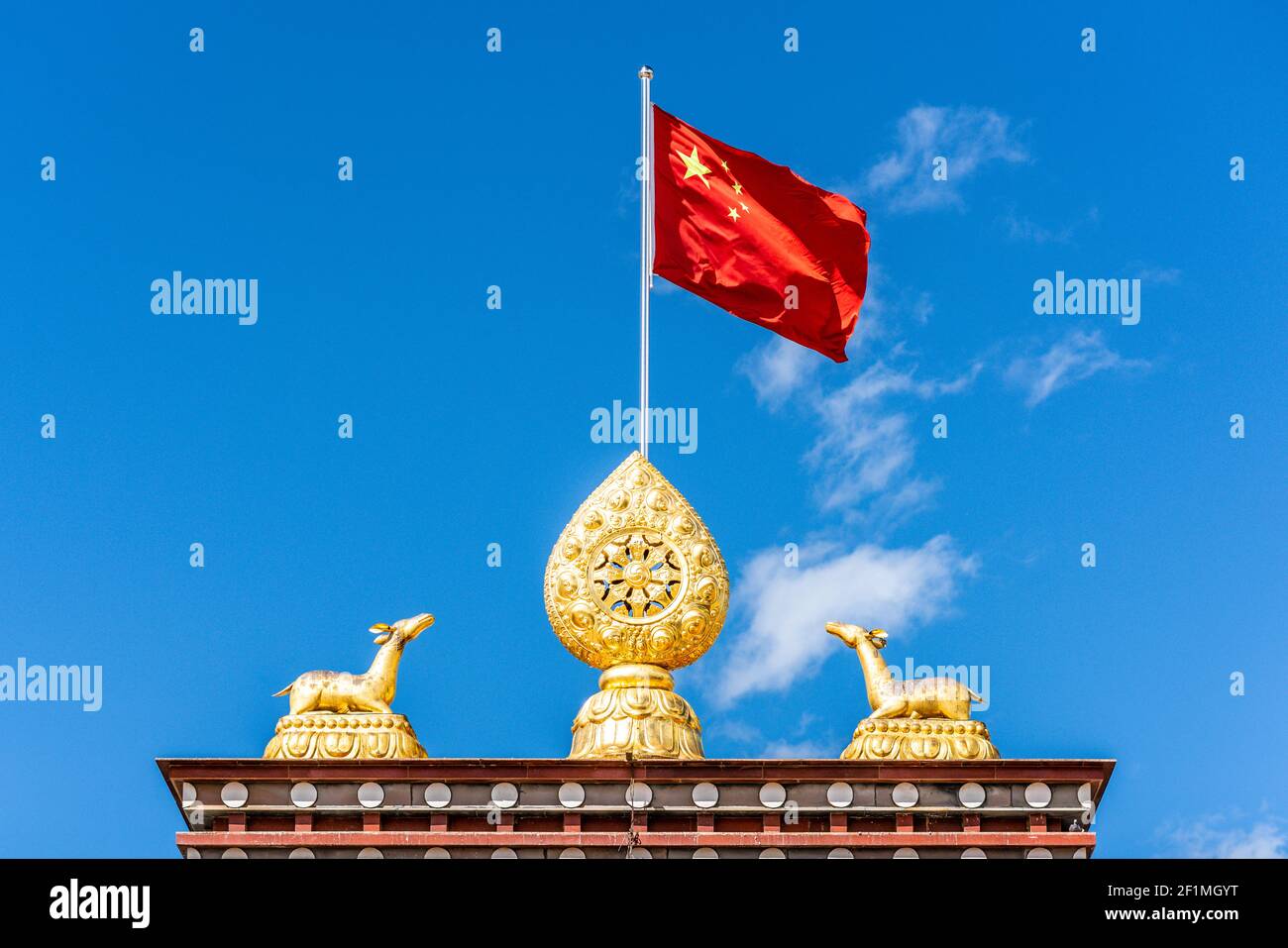 Ruota del Dharma e bandiera cinese che sventolano al buddista tibetano di Songzanlin Monastero di Shangri-la Yunnan Cina Foto Stock