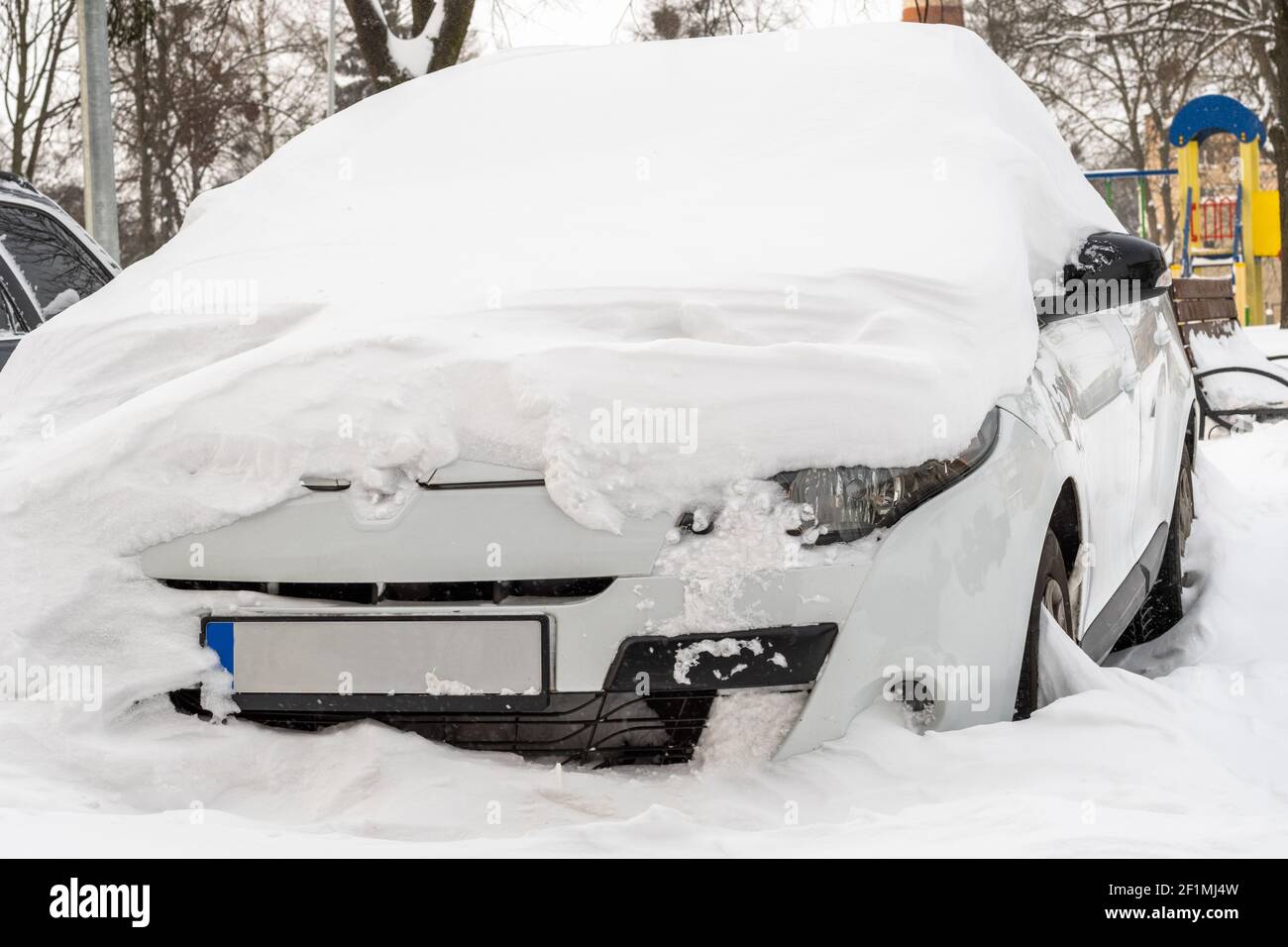 Città strada dopo Blizzard. Automobili bloccate sotto la neve e il ghiaccio. Veicolo sepolto in una deriva da neve sulla strada. Parcheggio in inverno dopo una nevicata pesante Foto Stock