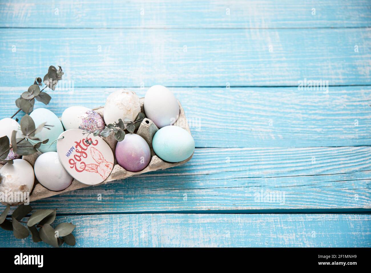 Primo piano di un vassoio con le uova di Pasqua festive su una superficie di legno copia spazio. Buon concetto di Pasqua. Foto Stock