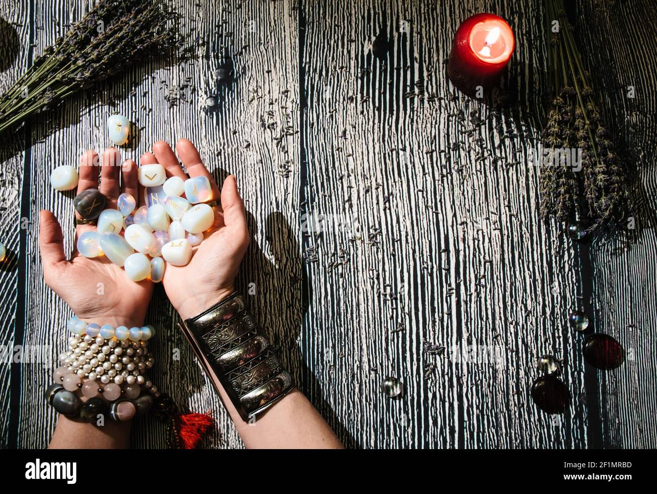 Mani di fortuneteller con rune di pietra, vista dall'alto. Previsione del futuro. Interno Mystic. Foto Stock