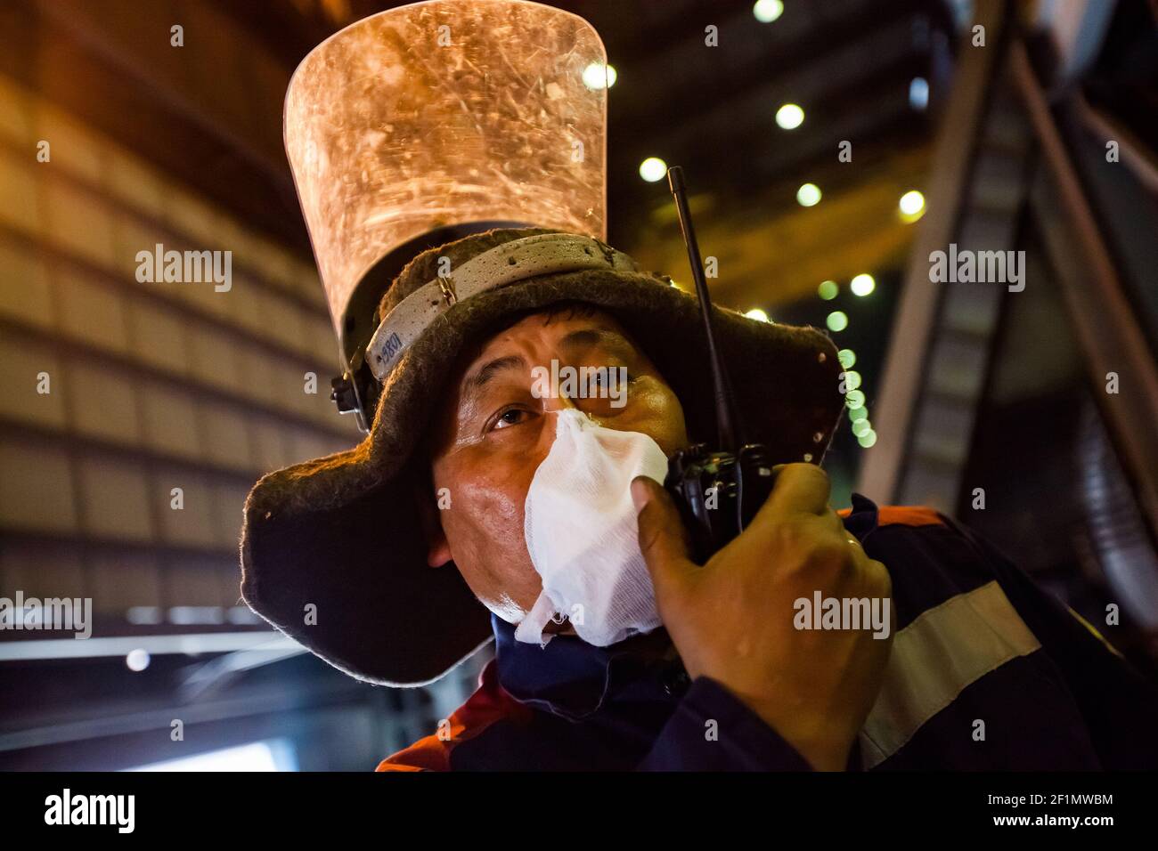 Impianto metallurgico di rame (fonderia).Ritratto di metallurgista asiatico senior in felt Hat, vetro protettivo e facciale mask.Kazakhstan, Ust'-Kamenogorsk. Foto Stock