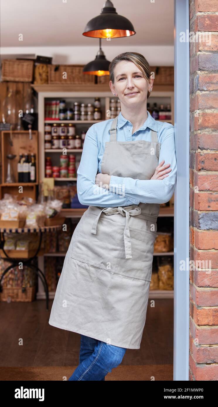 Ritratto di Proprietario femminile in piedi alla porta di Delicatessen Food Negozio Foto Stock