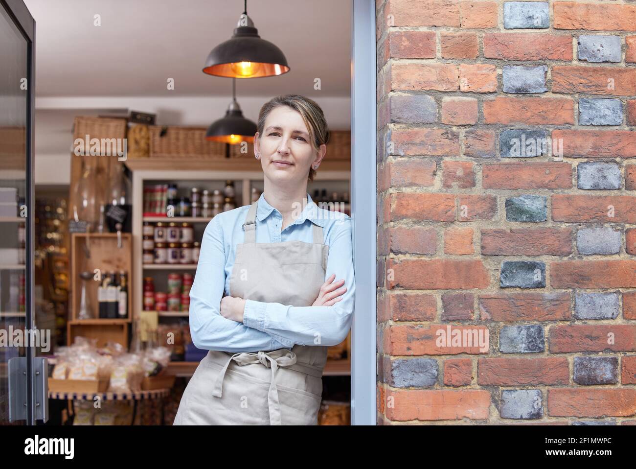 Ritratto di Proprietario femminile in piedi alla porta di Delicatessen Food Negozio Foto Stock
