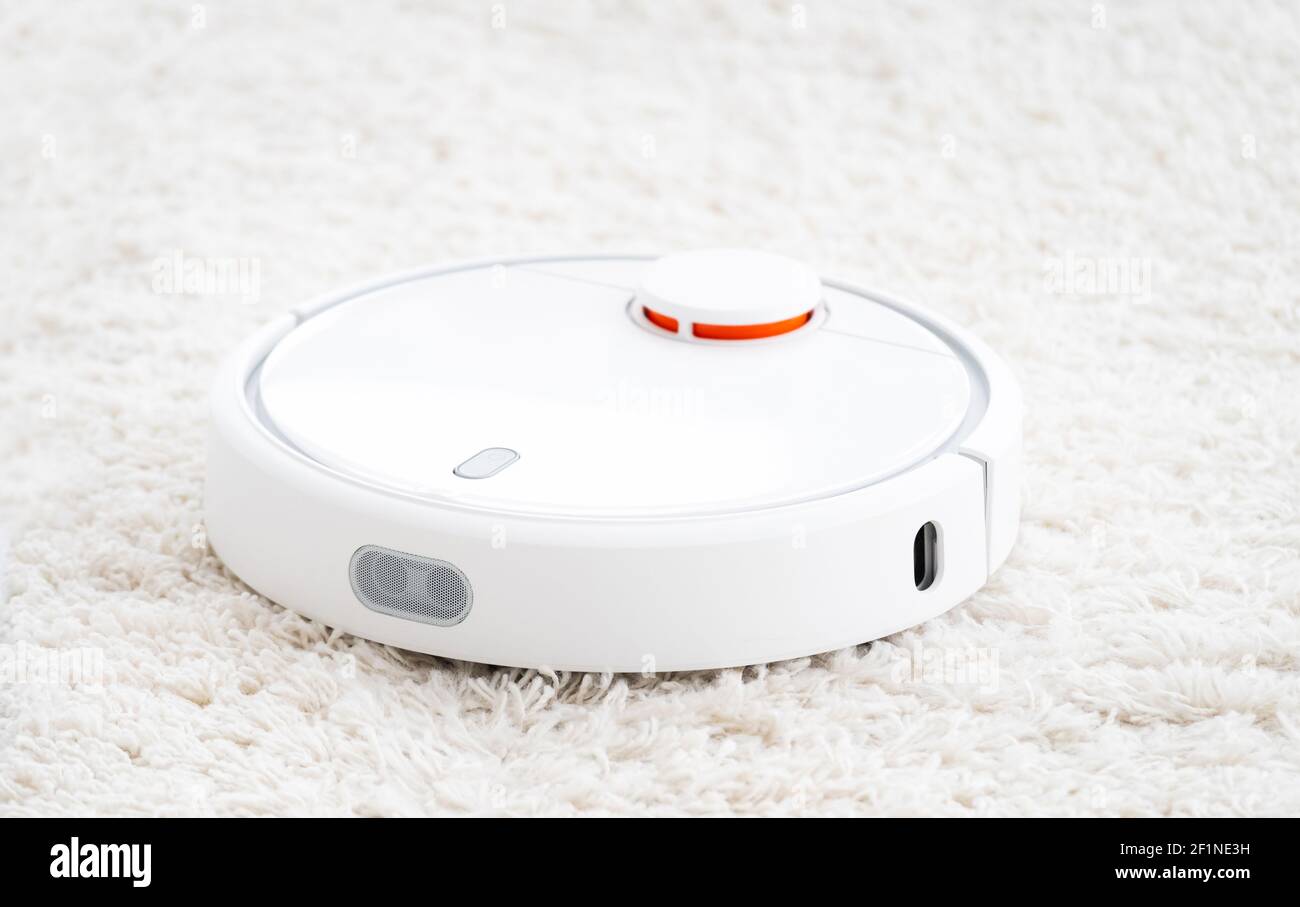 Aspirapolvere robot wireless su tappeto bianco Foto Stock