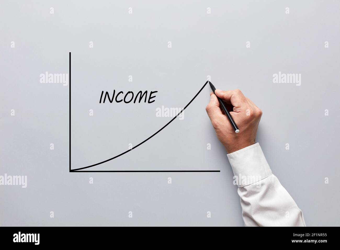 Mano maschile che disegna un grafico del reddito di affari su sfondo grigio. Concetto di aumento del reddito di affari, di stipendio o di salario. Foto Stock