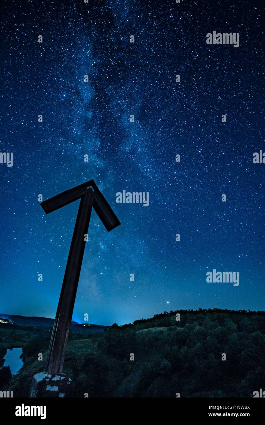 Freccia che punta in modo lattiginoso nel cielo notturno Foto Stock