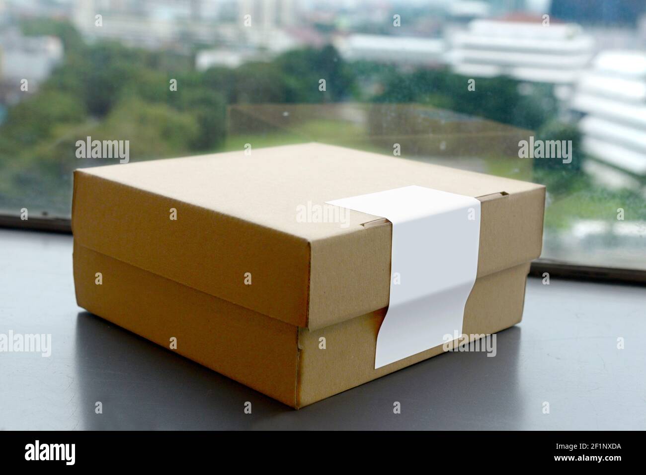 Scatola di cartone accanto al vetro del finestrino Foto Stock