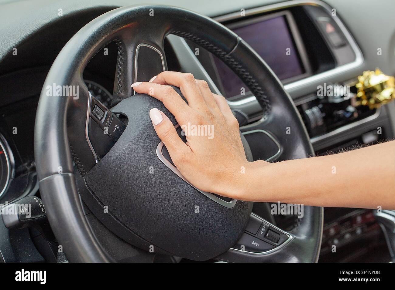 Donna mano su un volante e honking un corno con la sua mano destra Foto  stock - Alamy