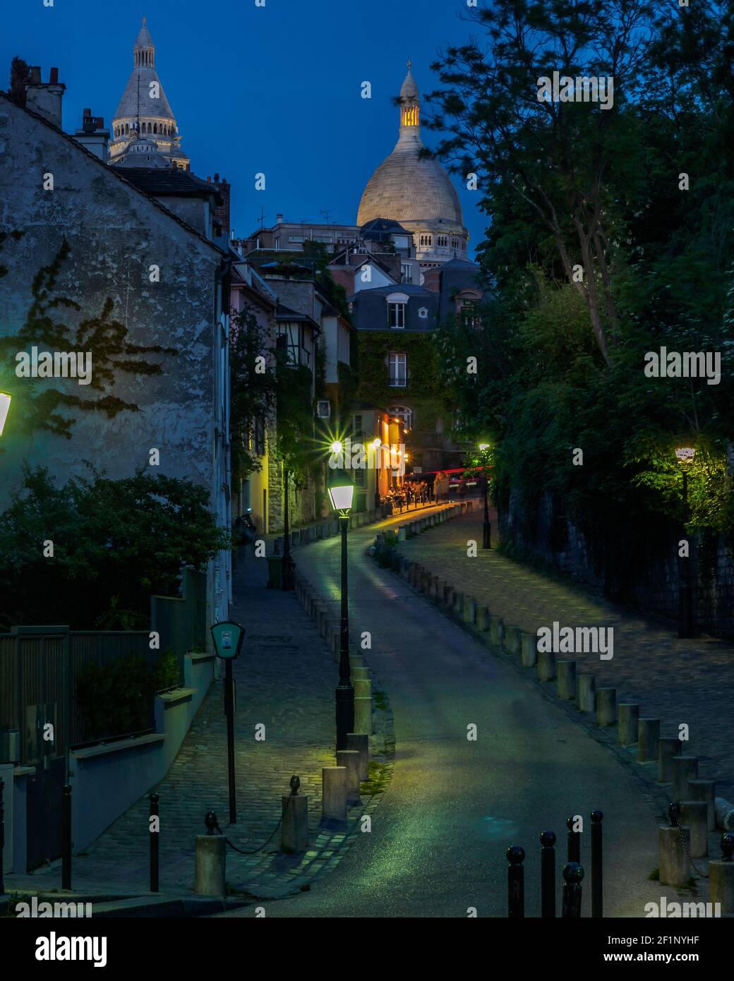 L'ultima luce della sera sul Sacro cuore e una piccola strada nel quartiere di Montmartre di Parigi, Francia. Foto Stock