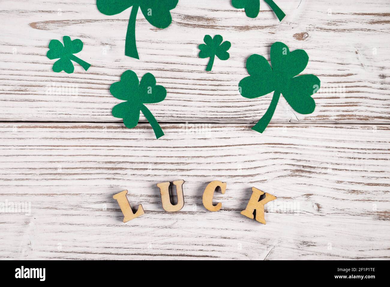 Parola fortuna e foglie di trifoglio di shamrock su sfondo bianco di legno. Buon giorno di San Patrizio. Vacanza irlandese. Foto Stock