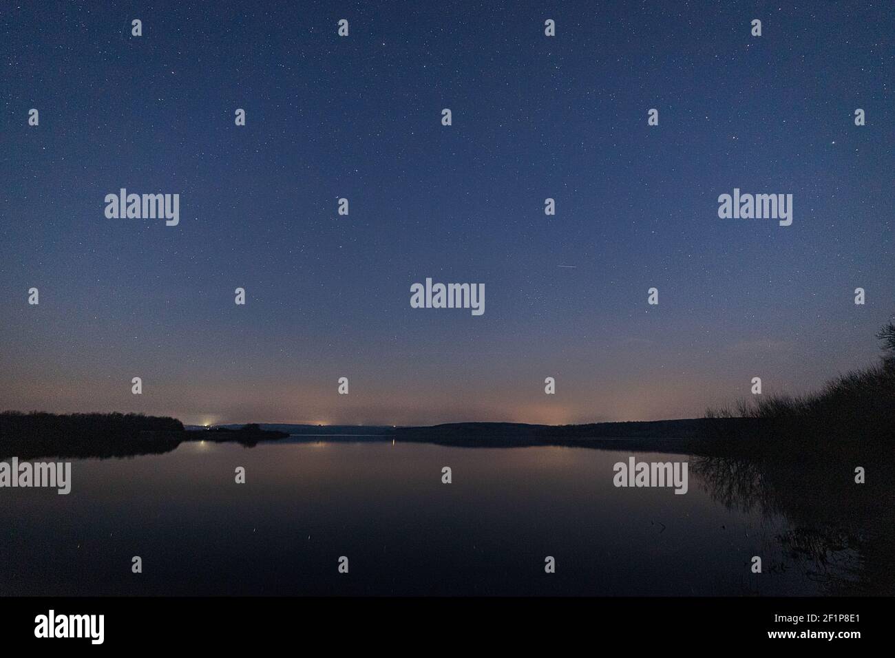 Paesaggio notturno con stelle su un lago calmo con spazio per la copia Foto Stock