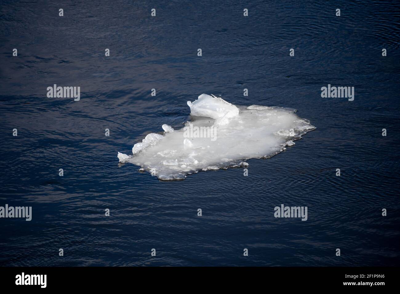 Pezzo di ghiaccio galleggianti che sgocciolano sul mare blu sotto il sole, ghiaccio fusione, cambiamento climatico, riscaldamento globale concetto Foto Stock