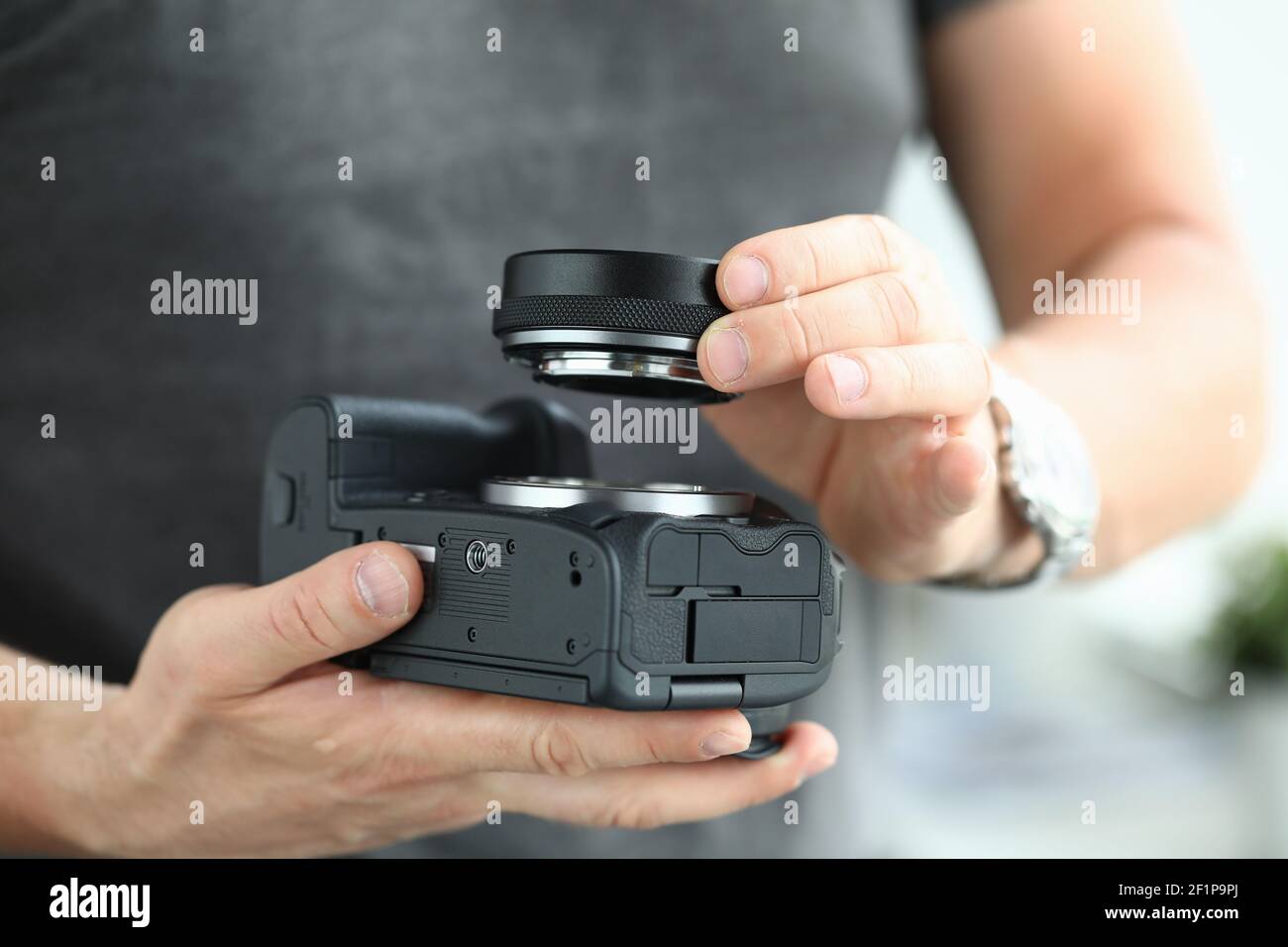 Mani maschili che indossano un moderno adattatore per obiettivo per fotocamera digitale Foto Stock