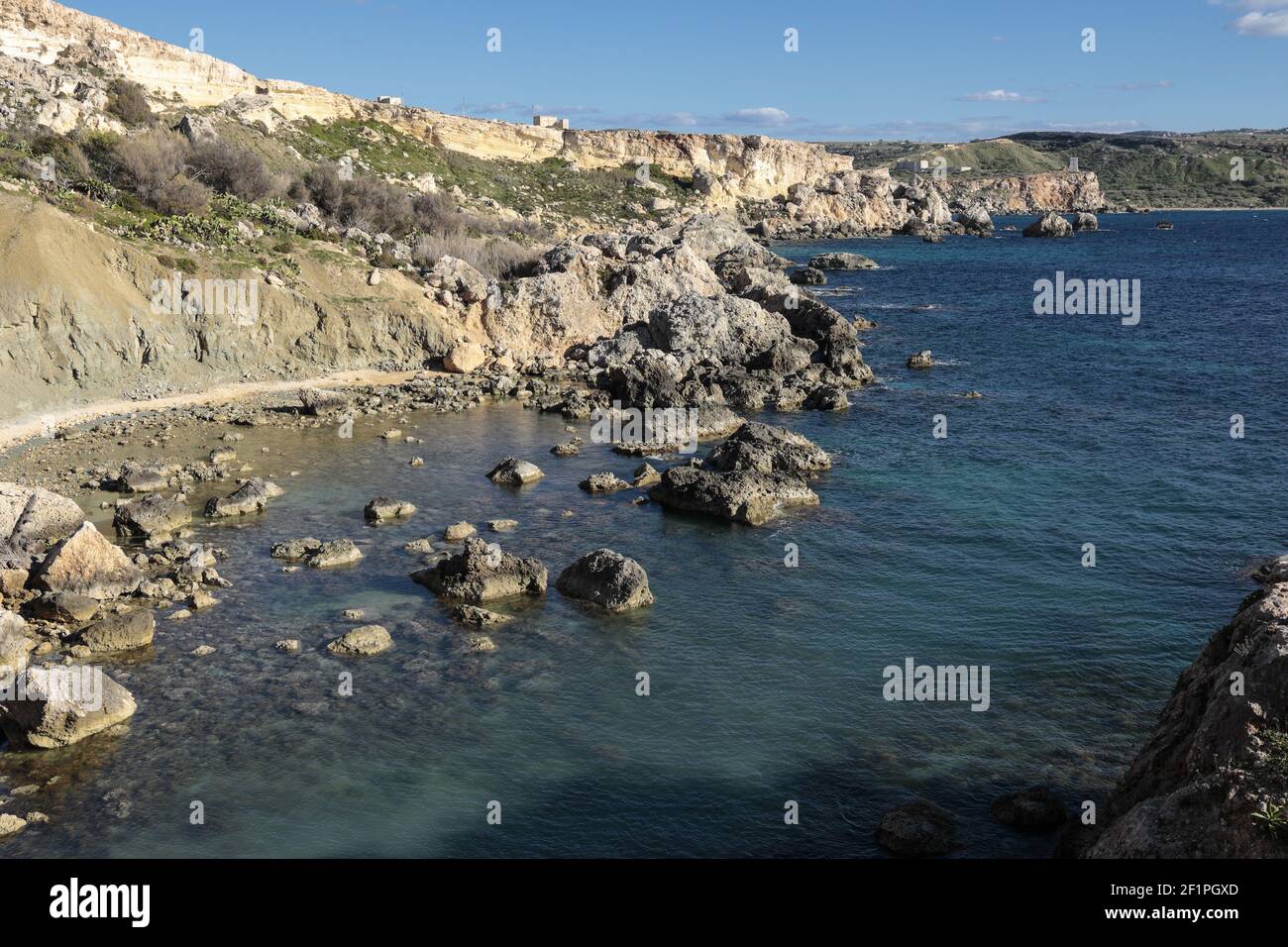 Alte scogliere calcaree coralline, sottostanti pendii di Blue Clay, scogliere di Blue Clay a sostegno delle spiagge . Boulder Stregn Shore. Costa occidentale, Malta Foto Stock