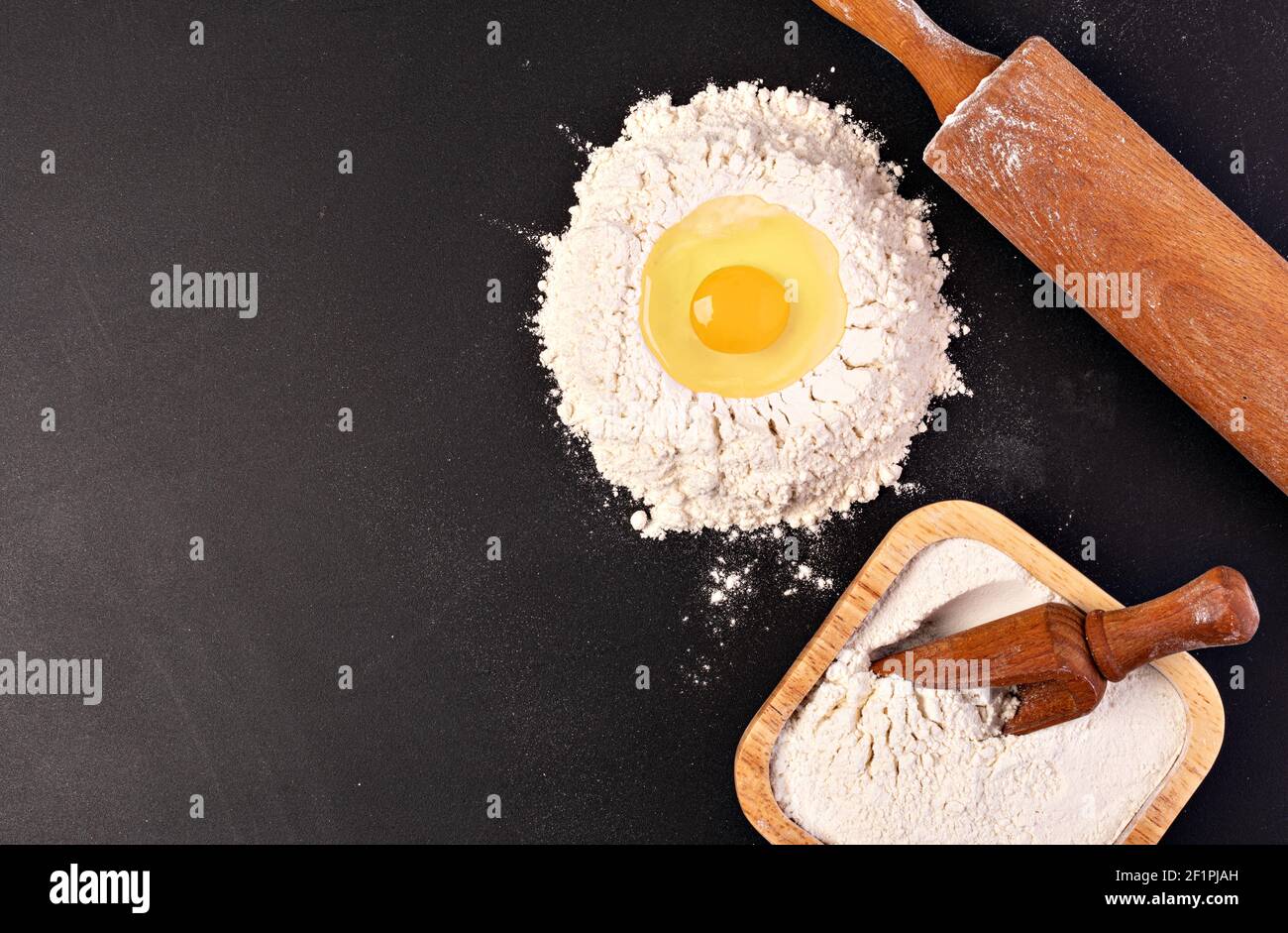 Mattarello e farina bianca su sfondo scuro Foto Stock