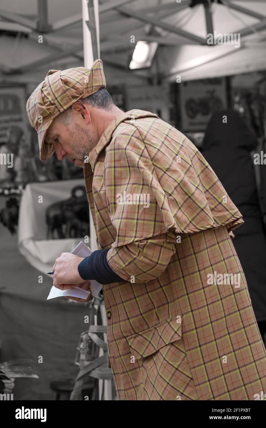 Sherlock Holmes personaggio che indossa cappello da capo e cervo al Gloucester Quays Victorian Christmas Market, Gloucester, Gloucestershire nel mese di novembre Foto Stock