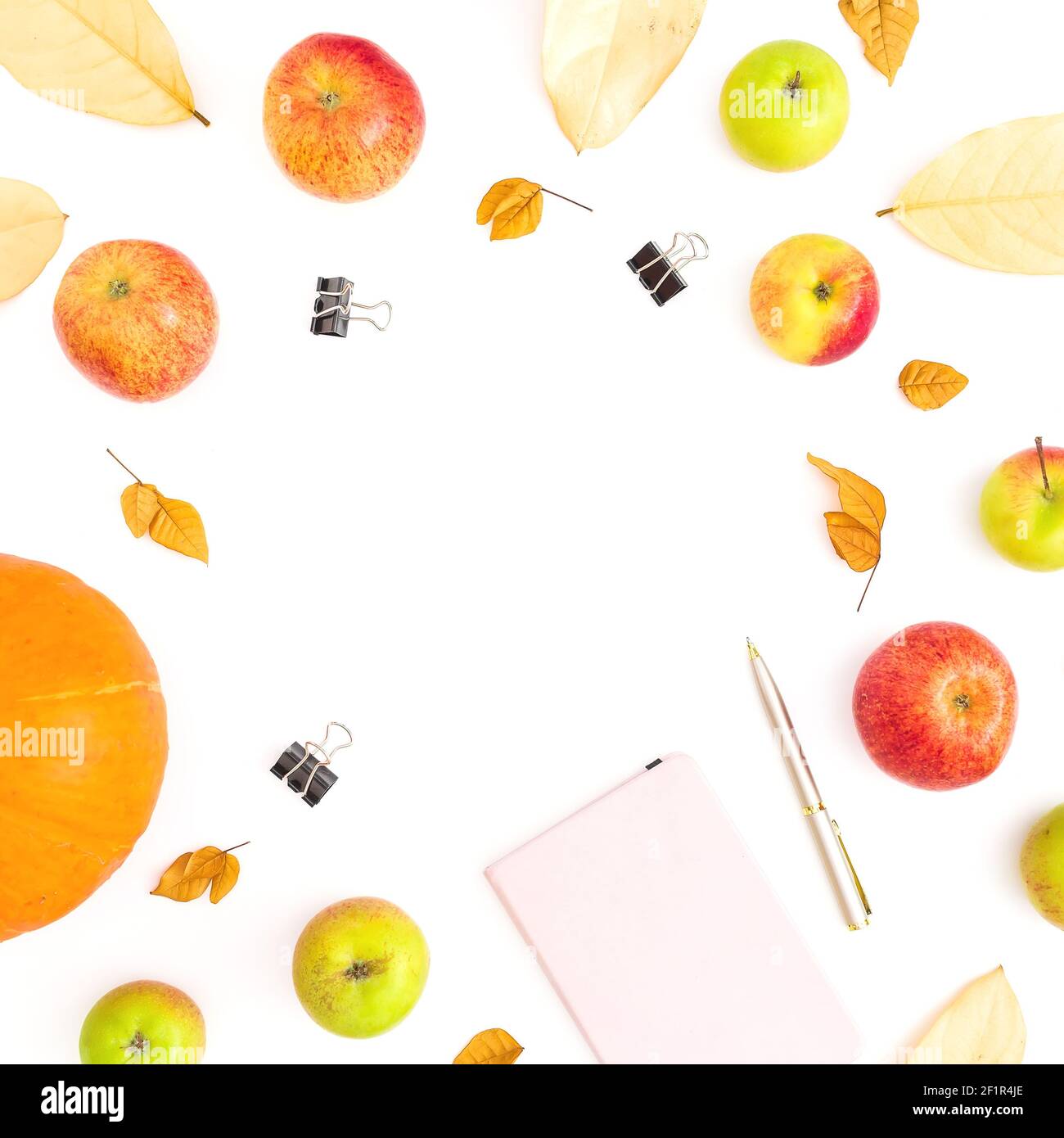 Composizione alimentare con frutta di mela e zucca, taccuino, penna e clip su sfondo bianco. Disposizione piatta, vista dall'alto Foto Stock