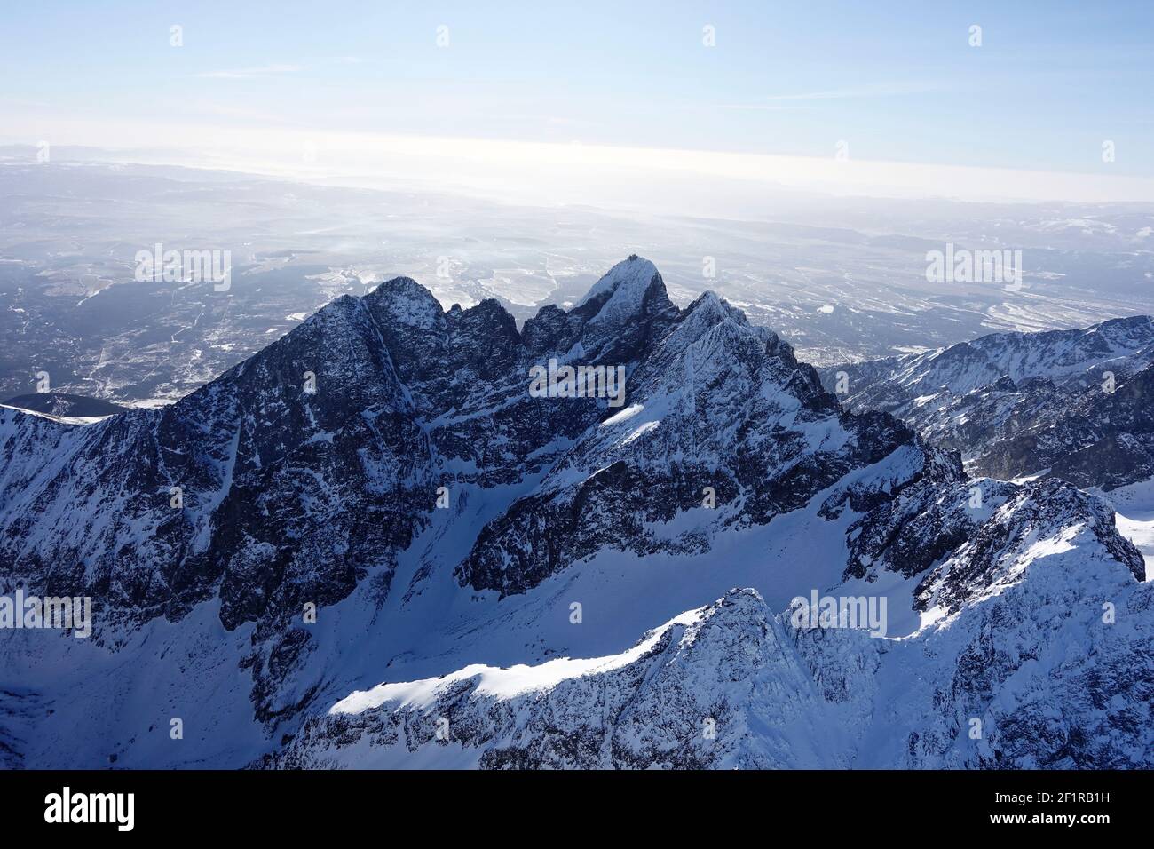 Vista sul drone della catena montuosa innevata durante il giorno di sole Foto Stock