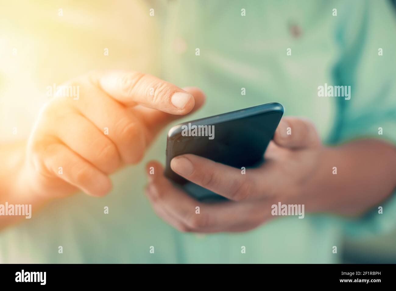Uomo d'affari scrive un messaggio e cerca i contatti sul tuo cellulare. Foto di alta qualità Foto Stock