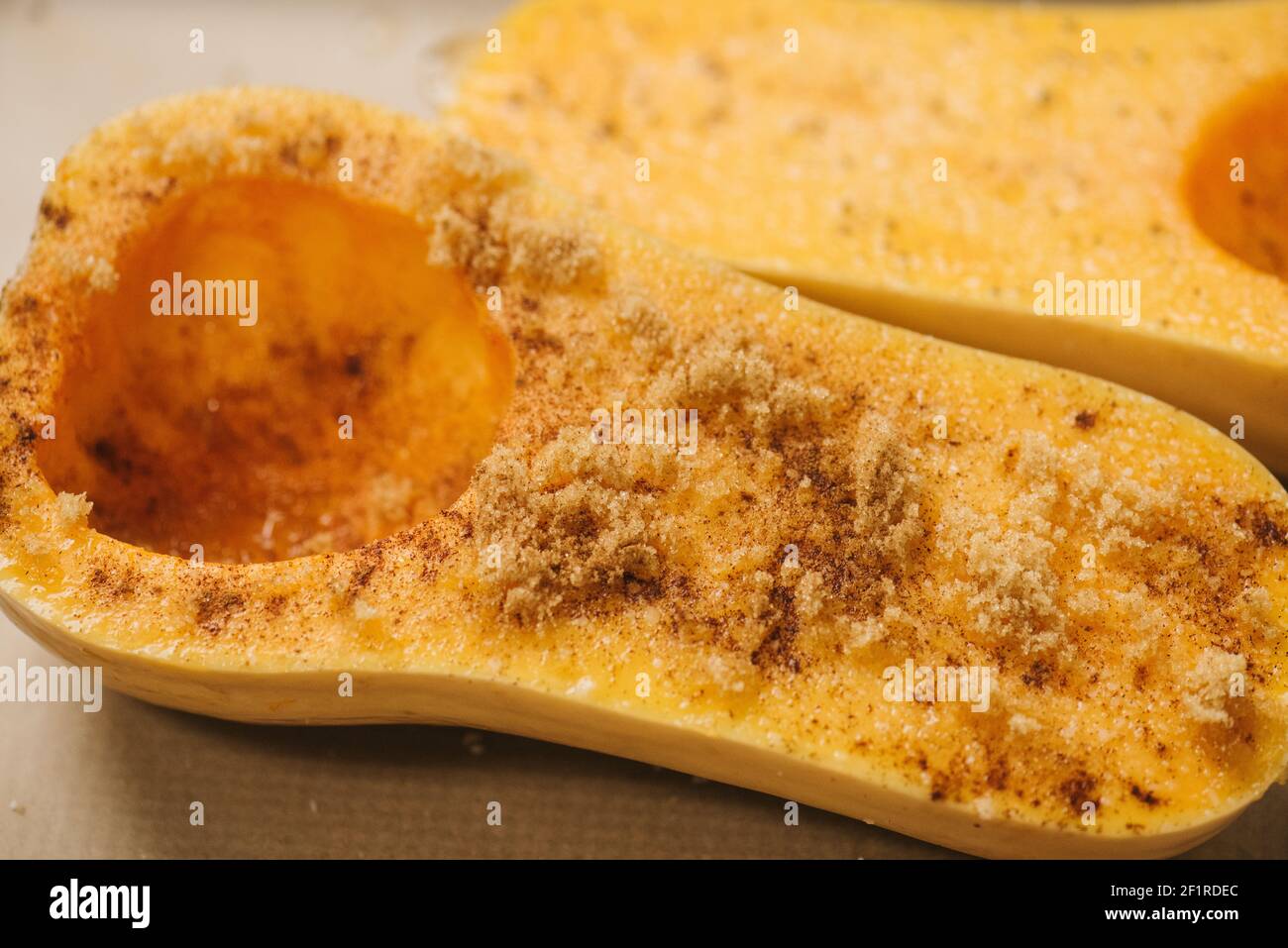 La zucca di butternut è stata dimezzata e ricoperta di zucchero di canna prima della cottura Foto Stock