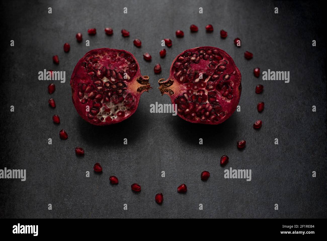 Primo piano di melograno su tavolo scuro. Concetto di amore Foto Stock