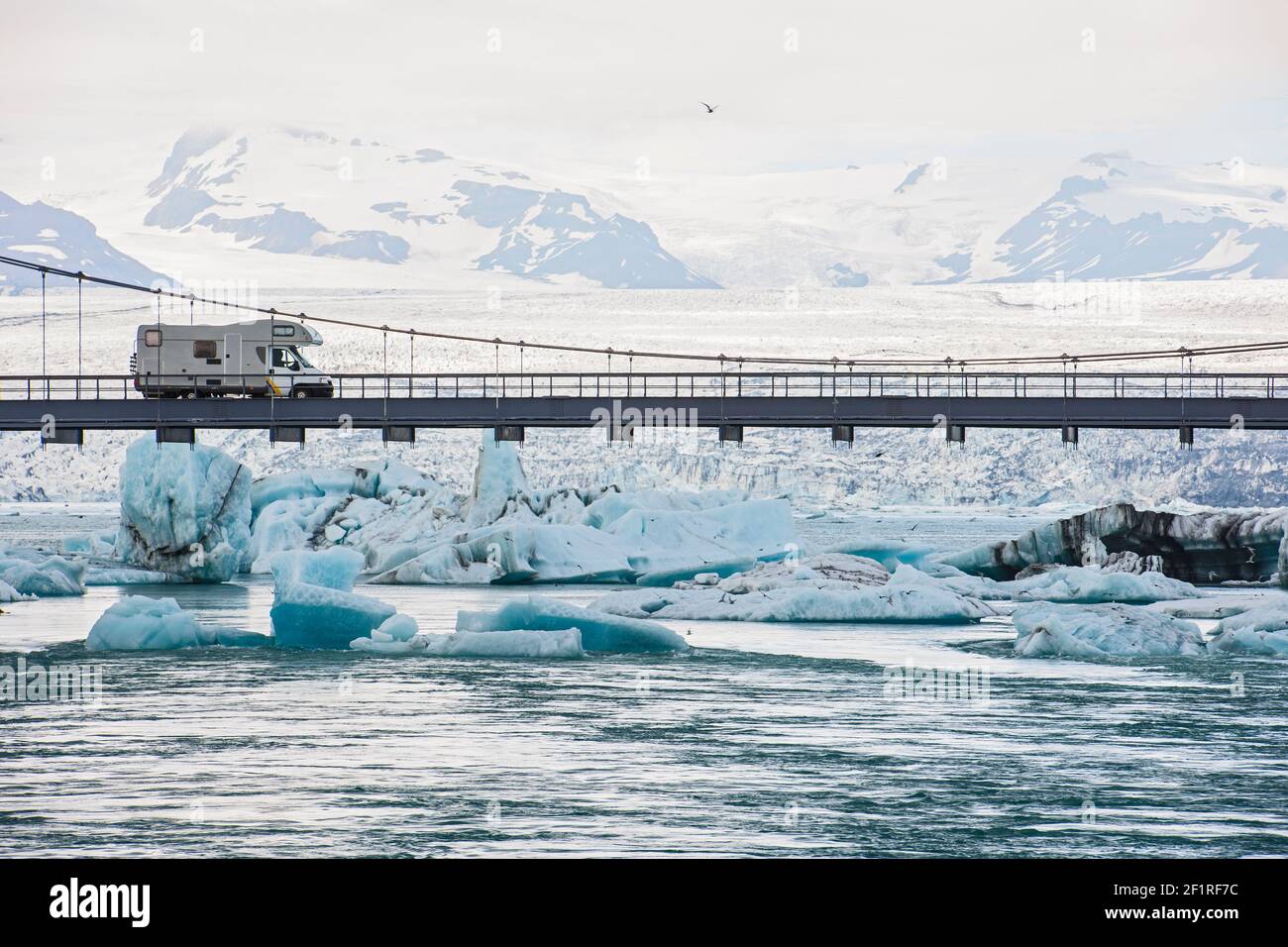 RV guida sul ponte sospeso sopra la laguna del ghiacciaio Jökulsárlón Foto Stock