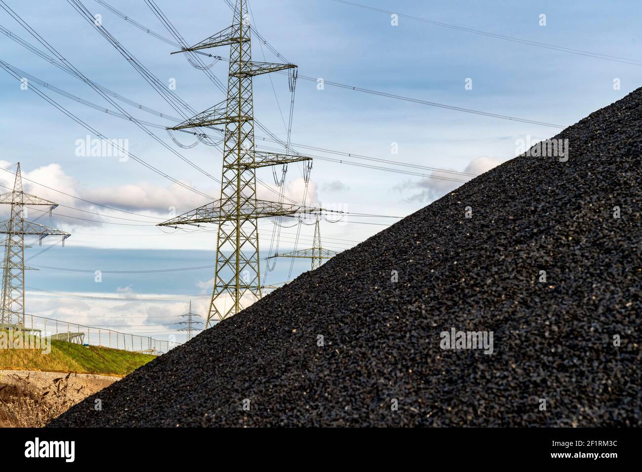 Discarica di carbone, giacenza di carbone, centrale di carbone, per la centrale termica combinata STEAG Herne, piloni ad alta tensione, sul canale Reno-Herne, Herne Foto Stock