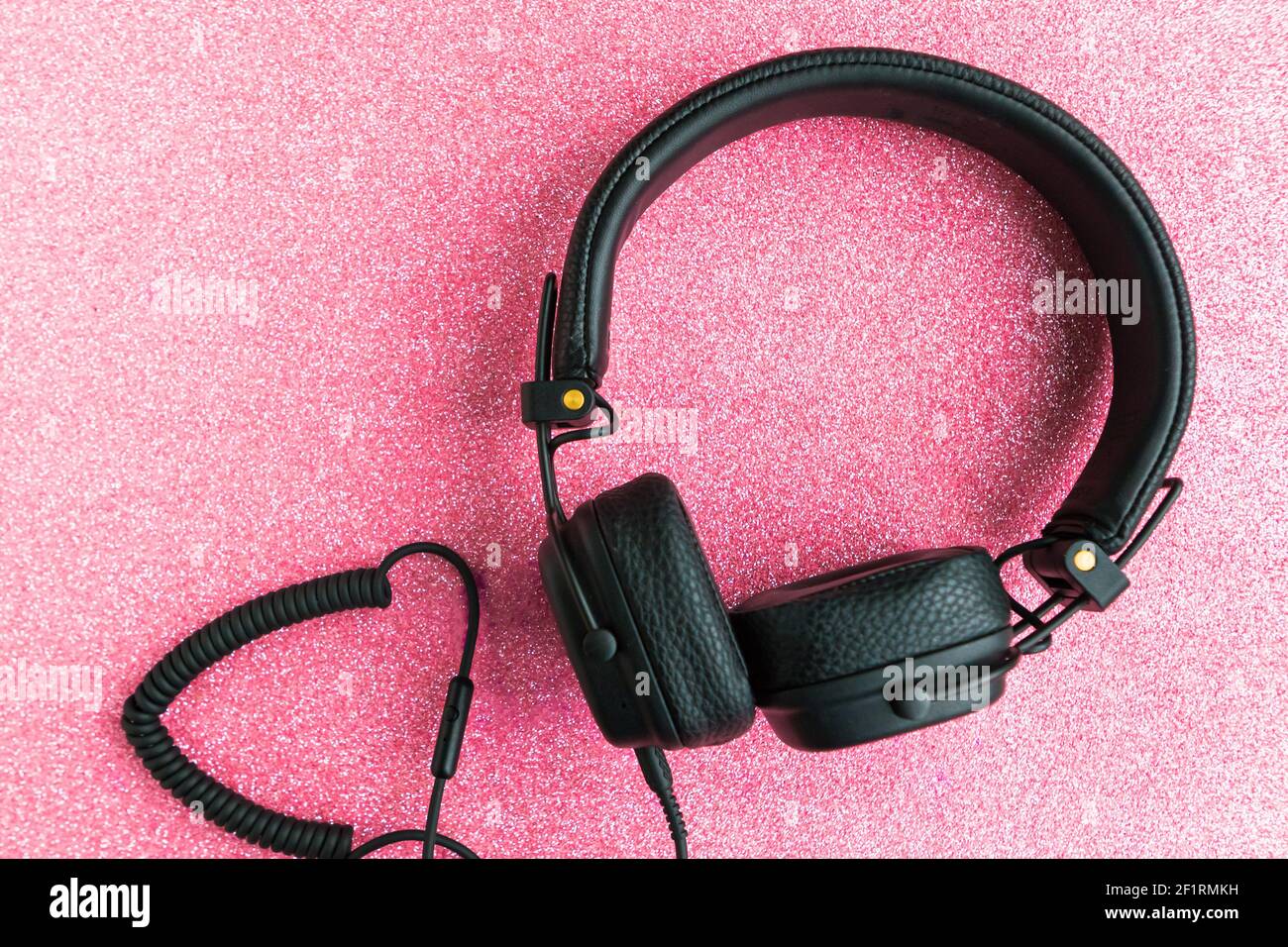 Cuffie nere grandi su sfondo rosa glitter Foto stock - Alamy