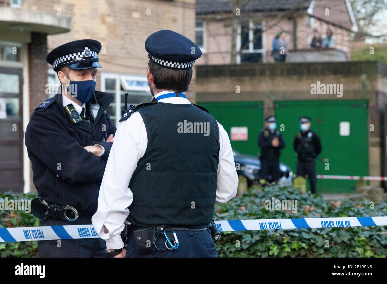 Londra, Regno Unito, 9 marzo 2021: La polizia sta cercando un blocco di appartamenti, Poynders Court, sulla A205 Poynders Road, e il MET ha confermato che è in relazione con la scomparsa di Sarah Everard. La donna di 33 anni manca dal 3 marzo. La polizia ha cordonato fuori la circolare sud e gli ufficiali in abiti forensi bianchi stanno aspettando in furgoni al bordo del cordone di polizia. Una folla di persone locali e giornalisti si è riunita e alcune persone stanno guardando gli eventi dai loro balconi. Anna Watson/Alamy Live News Foto Stock