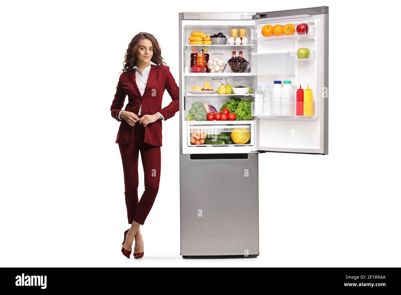 Ritratto a lunghezza intera di una giovane donna professionista appoggiata un frigorifero aperto isolato su sfondo bianco Foto Stock