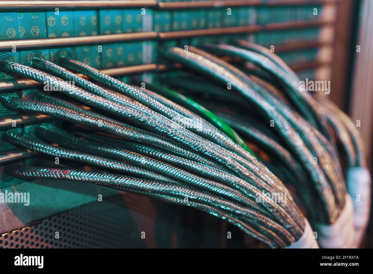 I fili tecnologici in una guaina metallica sono disposti in un canale per  cavi per trasmettere la tensione e gli impulsi dai sensori. Cavo di  alimentazione in una guaina rinforzata Foto stock -