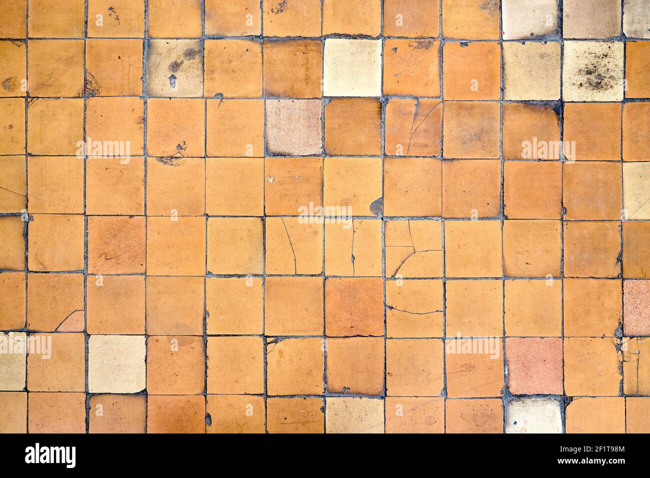 Arancio marrone bianco beige vecchio shabby usurato pavimento piastrelle con danni crepe caverne sporco buche e macchie di vernice. Texture di sfondo del disegno artistico. Foto Stock