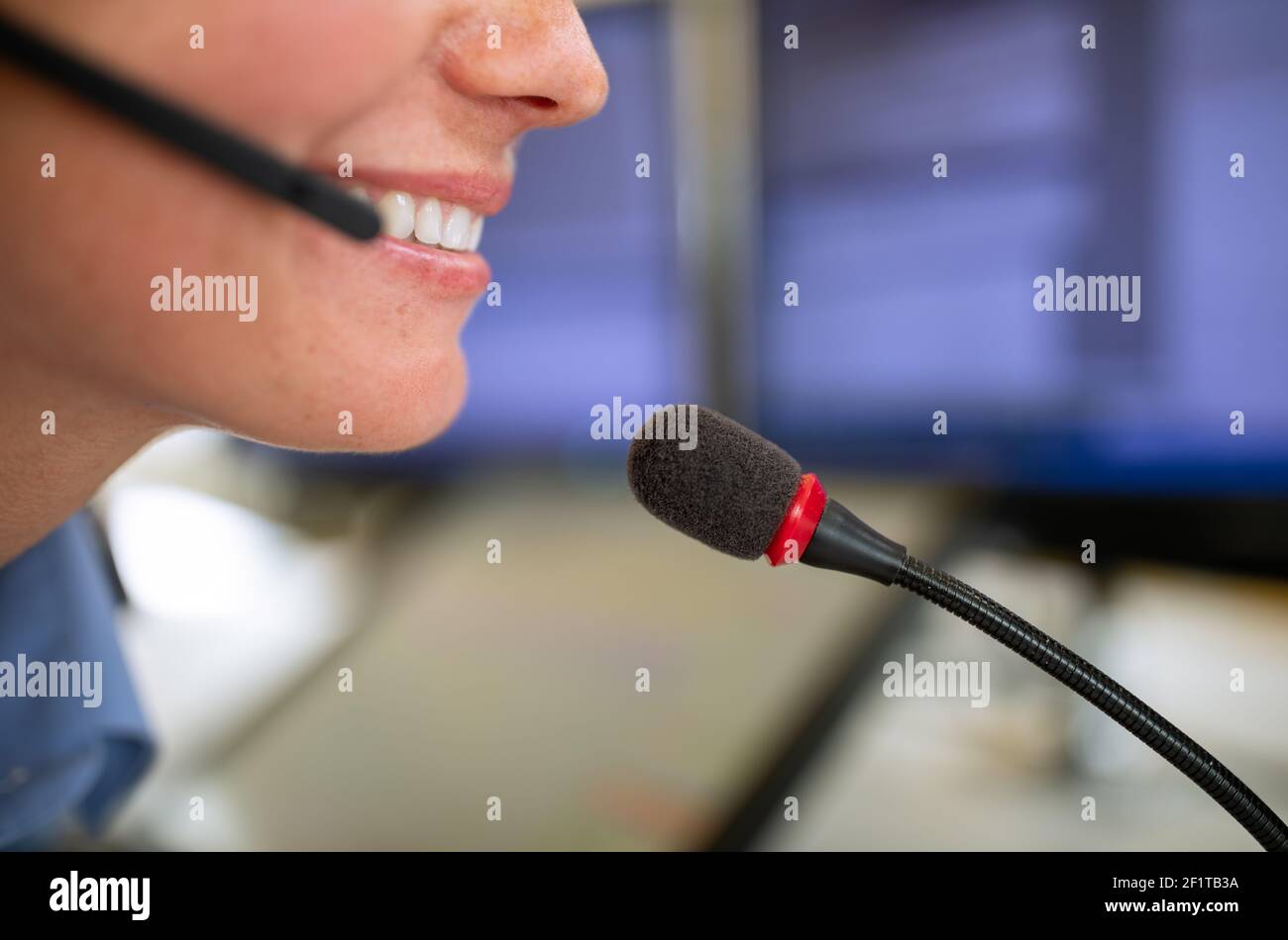 Il dipendente del call center comunica tramite telefono utilizzando un microfono  esterno per una migliore ergonomia e sounf Foto stock - Alamy