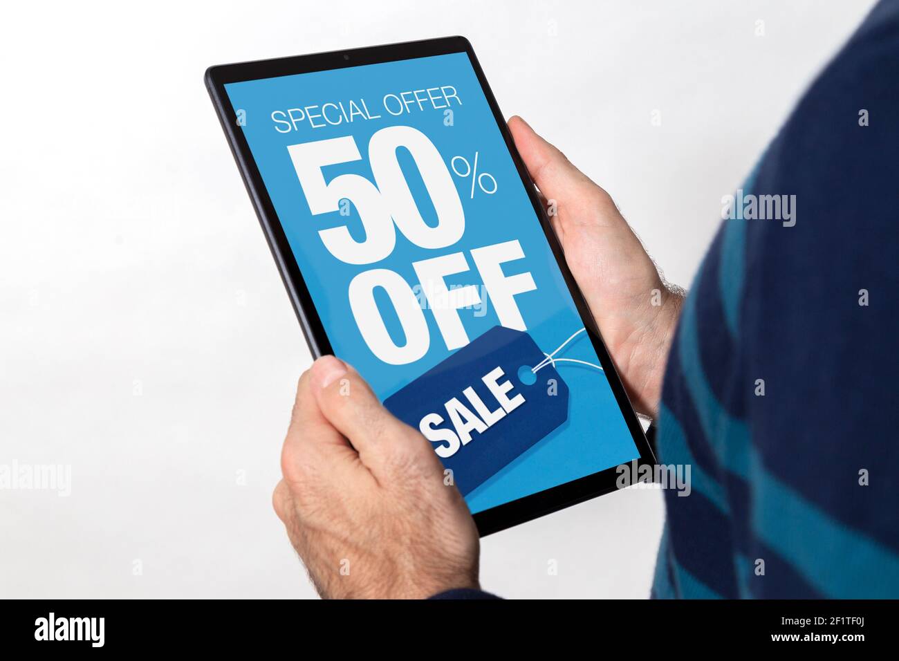 Uomo in possesso di un tablet con il 50% di sconto sulla pubblicità di vendita sullo schermo. Sfondo bianco. Foto Stock